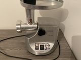 a silver and black blender sitting on a wooden table