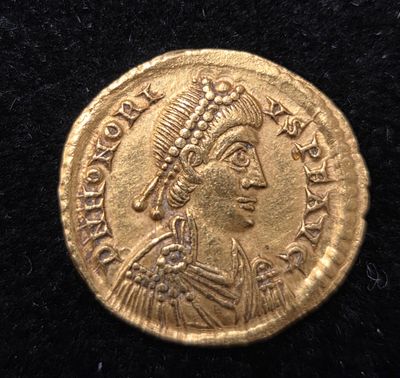 une pièce d'or sur laquelle figure l'effigie d'une femme portant une coiffe