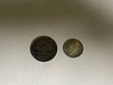 two coins sitting on top of a table next to each other