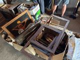 a man that is standing next to a pile of framed pictures