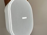 a white speaker on a wooden post in a room