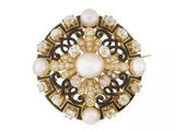 un gros plan sur une broche ornée de perles et de diamants