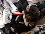 many pairs of shoes in a basket on the floor