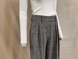the mannequin is wearing a white top and gray pants