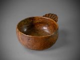 an old wooden bowl sitting on top of a gray surface