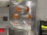 several donuts are wrapped in plastic in a commercial kitchen