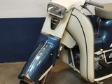 a blue and white motor scooter parked in a garage