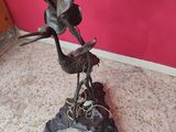a bronze statue of two birds on a stand