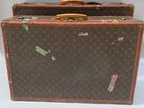 une paire de valises Louis Vuitton ornées d'autocollants