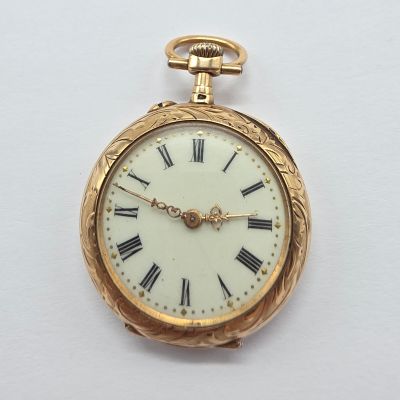 a gold pocket watch with roman numerals on the face