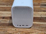 an image of a white speaker sitting on top of a wooden table