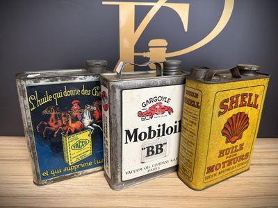 three vintage oil cans sitting on top of a table next to each other