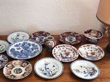 many plates and bowls sitting on a table with a lamp