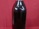 une bouteille de liquide posée sur une surface rouge