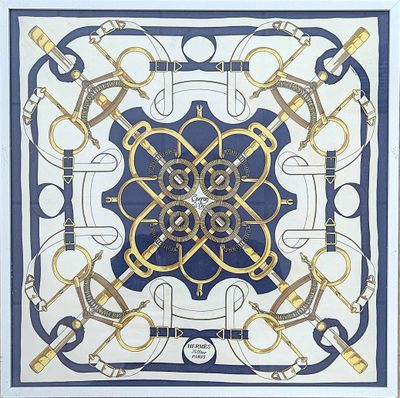une photo d'un foulard carré bleu et blanc orné d'un motif doré et noir