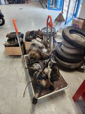 un chariot rempli de vieux pneus et une brouette dans un garage