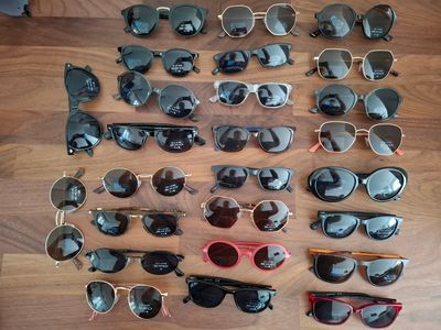 de nombreuses paires de lunettes de soleil posées sur une table en bois
