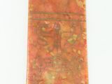 an image of a piece of red jasper stone on a white surface