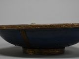 an image of a blue bowl with a gold rim on a white surface