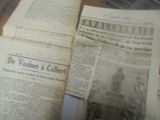 Plusieurs vieux journaux sont empilés les uns sur les autres sur une table