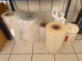 many rolls of paper sitting on the floor next to a shelf