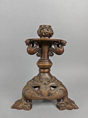 an antique bronze candle holder with a bird on top