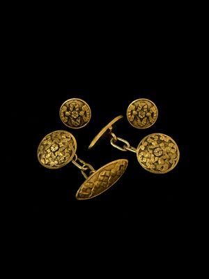a pair of gold cufflinks and a pair of cufflinks
