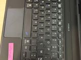 a black laptop with a pink sticker on the keyboard
