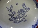 a blue and white plate with a bird and flowers on it