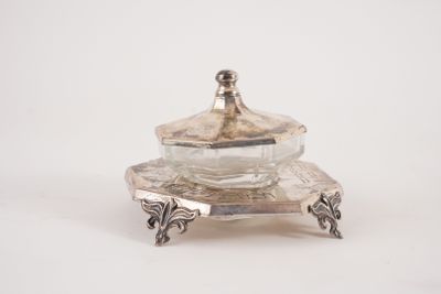 un plat en argent ancien surmonté d'un bol en verre