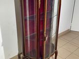 a display cabinet with a glass door in the corner of the room