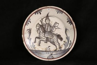 a plate with a picture of a man riding a horse