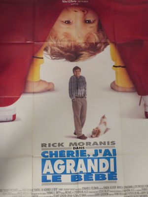 affiche de cinéma représentant un homme debout devant un rideau rouge