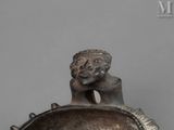 a statue of a man sitting on top of a vase