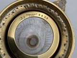 a close up of a gold colored clock on a table