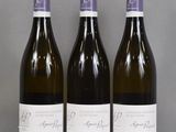 three bottles of wine are lined up on a glass table