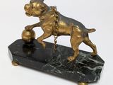bronze statue of a dog with a ball on a marble base