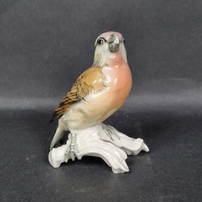 a small figurine of a bird sitting on a branch