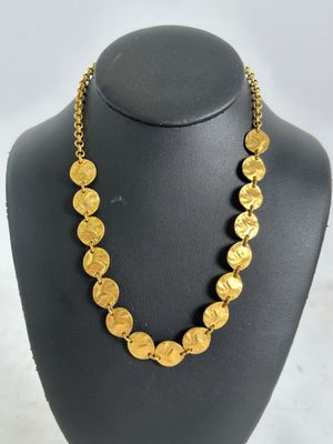 a necklace with gold coins on a mannequin