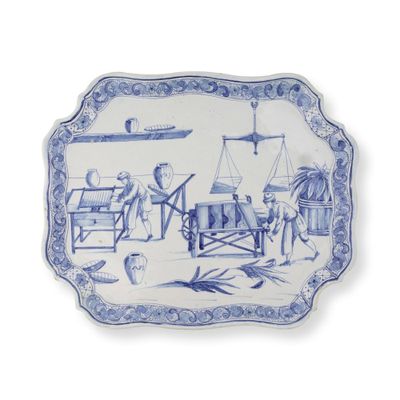 une assiette bleue et blanche sur laquelle est représenté un homme travaillant sur une machine