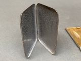 two pieces of metal on a table next to each other