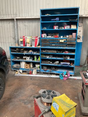 a picture of a car in a garage with a shelf full of tools