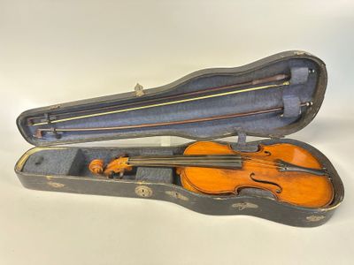 un vieil étui à violon contenant un violon, posé sur une surface blanche
