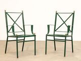 pair of green metal chairs with crossed arms and legs