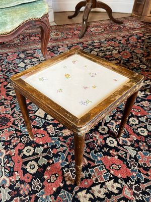 a small table with a small square top on a rug
