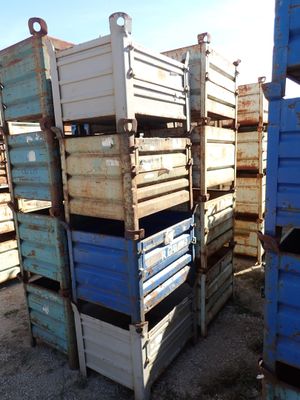 many blue crates stacked on top of each other in the dirt