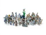 many figurines of different sizes and colors on a white surface