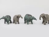 three small elephant figurines are standing in a row