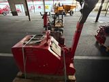 a red machine that is sitting on a pallet in a warehouse