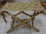 a small stool made of bamboo sticks and a rug on it